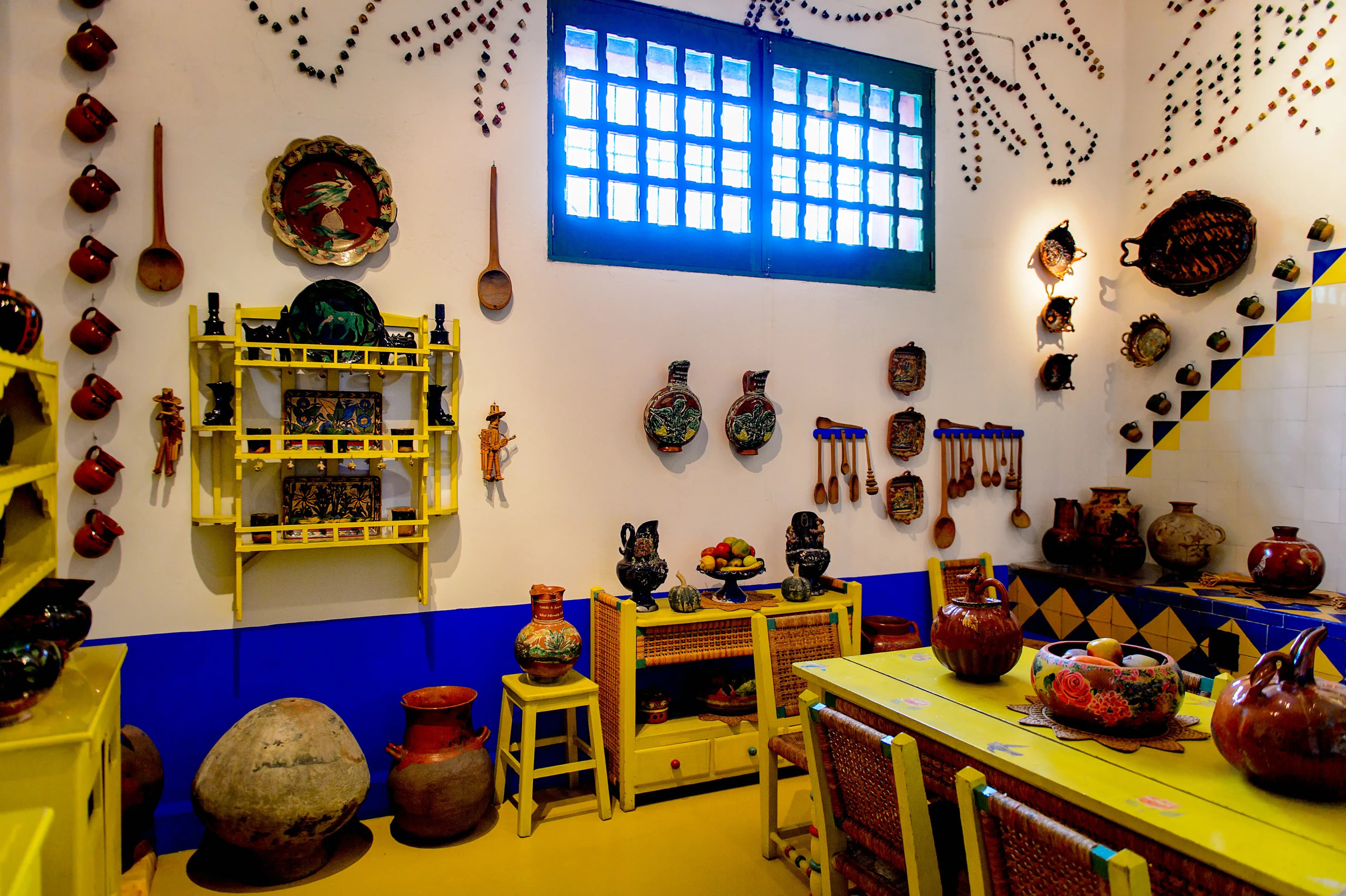 A colorful Casa Azul exterior with blue walls and lush courtyard greenery
